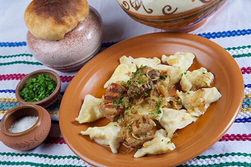 Pork and varenyky with cabbage filling in pots