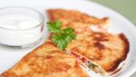 Pancakes with brynza (feta cheese) and tomatoes