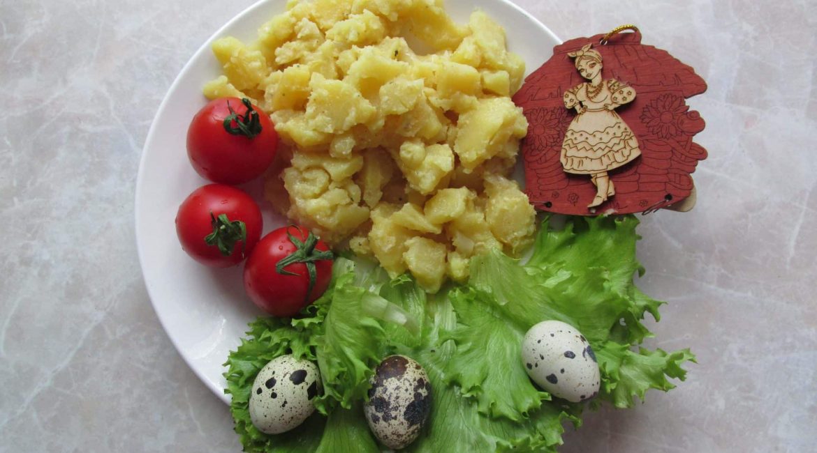 Oven-baked creamy potato with tomatoes and quail eggs