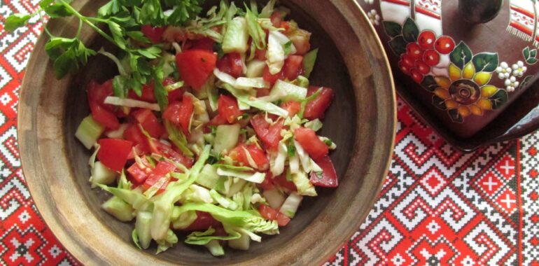 Cabbage, cucumber, and tomato salad dressed with olive oil